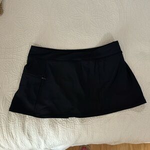 Women’s black swim skirt with attached boy leg shorts, zipper pocket, size 14